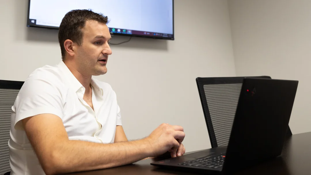 Ringba User Stories - Chris Shihadeh Working at his Laptop in a Meeting